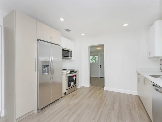 a kitchen with stainless steel appliances a refrigerator sink and stove
