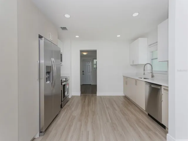 a view of a kitchen with a sink and refrigerator