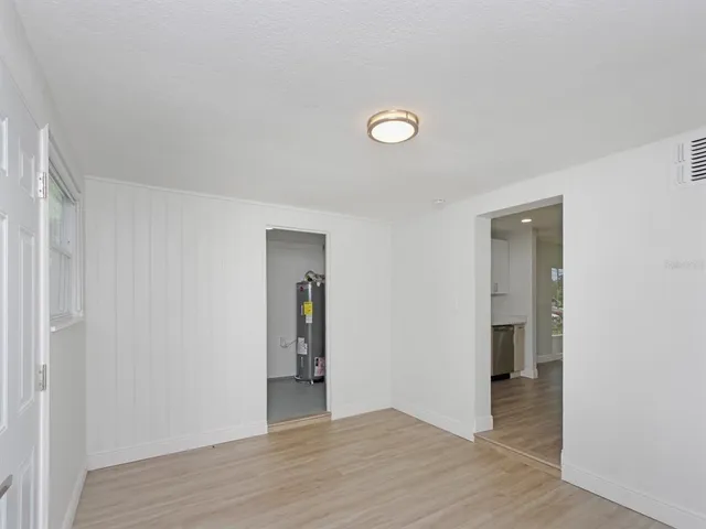an empty room with wooden floor and entrance