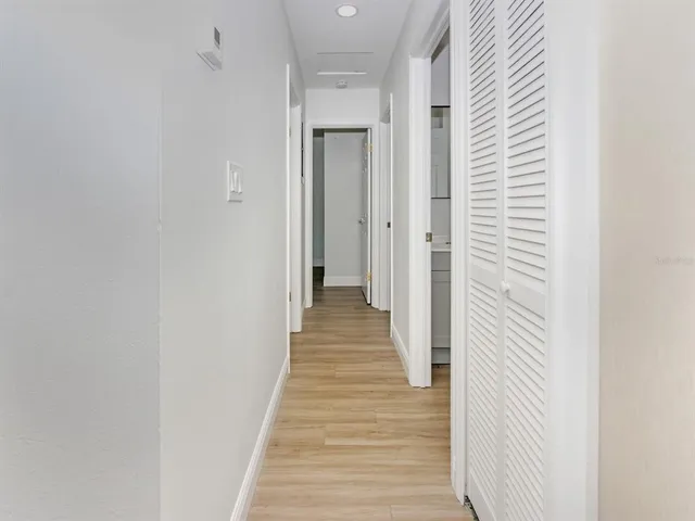 a view of a hallway with wooden floor and staircase