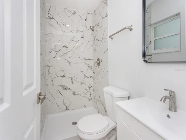 a bathroom with a toilet sink and shower