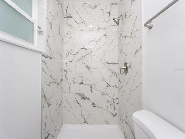 a bathroom with a toilet and a shower curtain