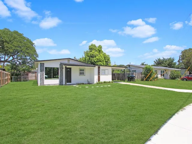 a view of a yard in front of a house with a large tree
