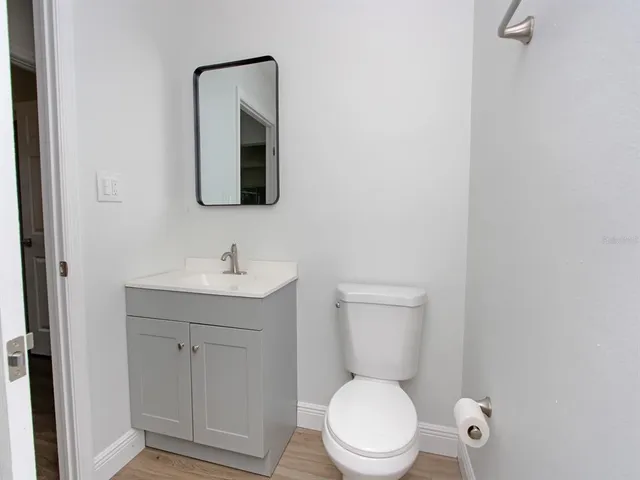 a bathroom with a toilet a sink a vanity and mirror
