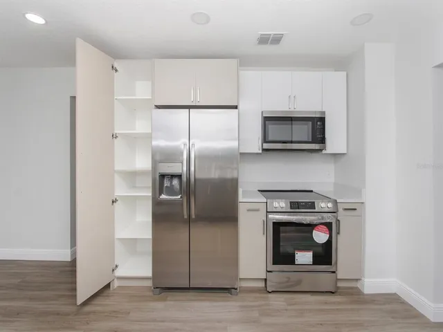 a kitchen with stainless steel appliances a stove a microwave and a refrigerator