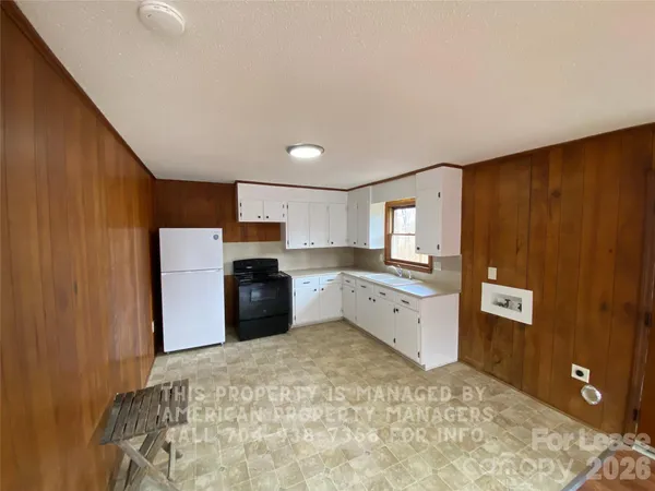 a kitchen with granite countertop cabinets and refrigerator