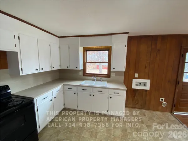 a kitchen with granite countertop white cabinets and sink