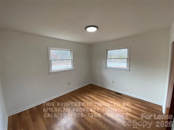a view of a room with wooden floor and fan
