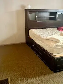 a bed sitting in a bedroom next to a cabinet