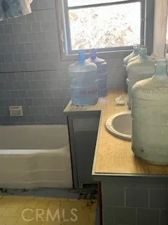 a bathroom with a granite countertop sink a bathtub and window