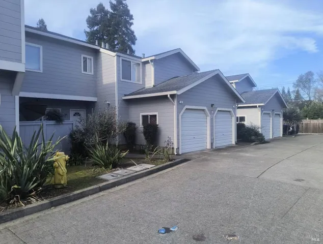 a view of a house with a yard and potted plants