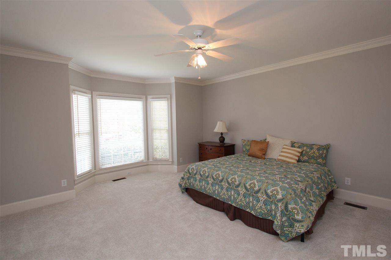 7121 Trenton Ridge Court Raleigh, NC 27613 - Photo 15 of 25 a bedroom with a bed and a chandelier