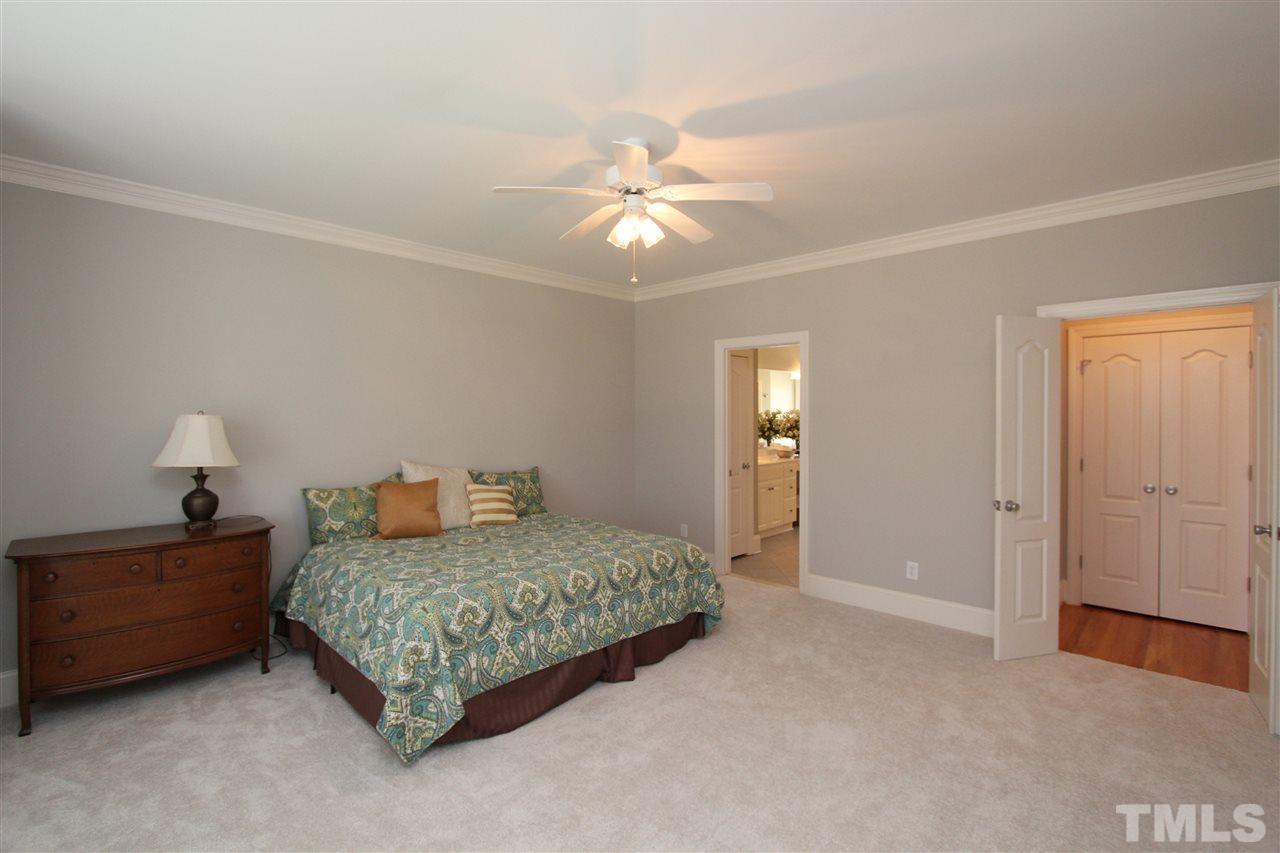 7121 Trenton Ridge Court Raleigh, NC 27613 - Photo 16 of 25 a bedroom with a bed and a chandelier fan
