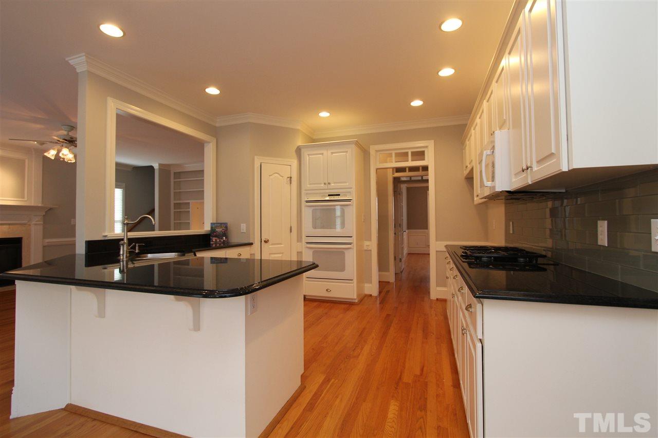7121 Trenton Ridge Court Raleigh, NC 27613 - Photo 7 of 25 a kitchen with a sink and refrigerator