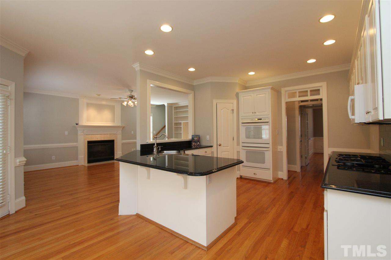 7121 Trenton Ridge Court Raleigh, NC 27613 - Photo 8 of 25 a large white kitchen with a stove a sink dishwasher and a refrigerator with wooden floor