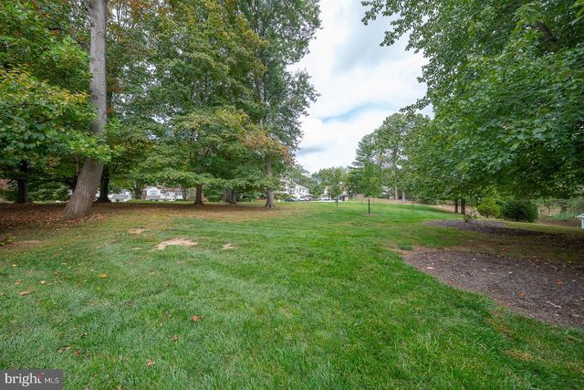 a view of a house with a big yard and large trees