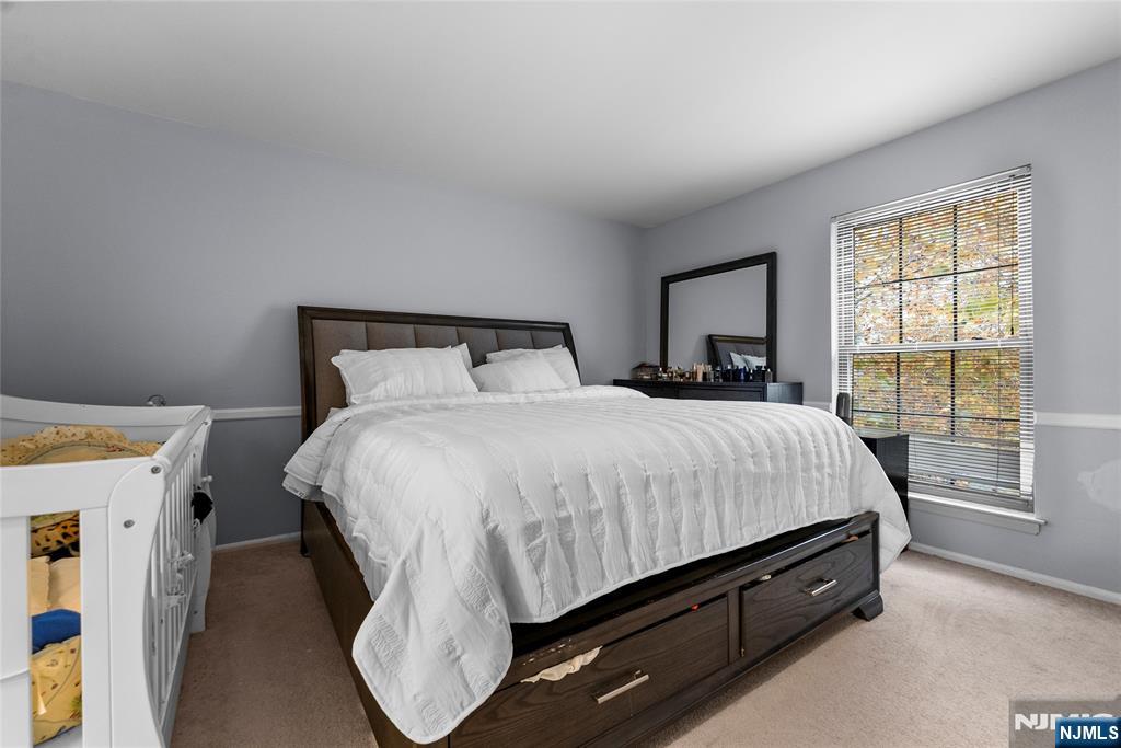 181 Long Hill Road, Unit 116 Little Falls, NJ 07424 - Photo 11 of 19 a bed sitting in a bedroom next to a window