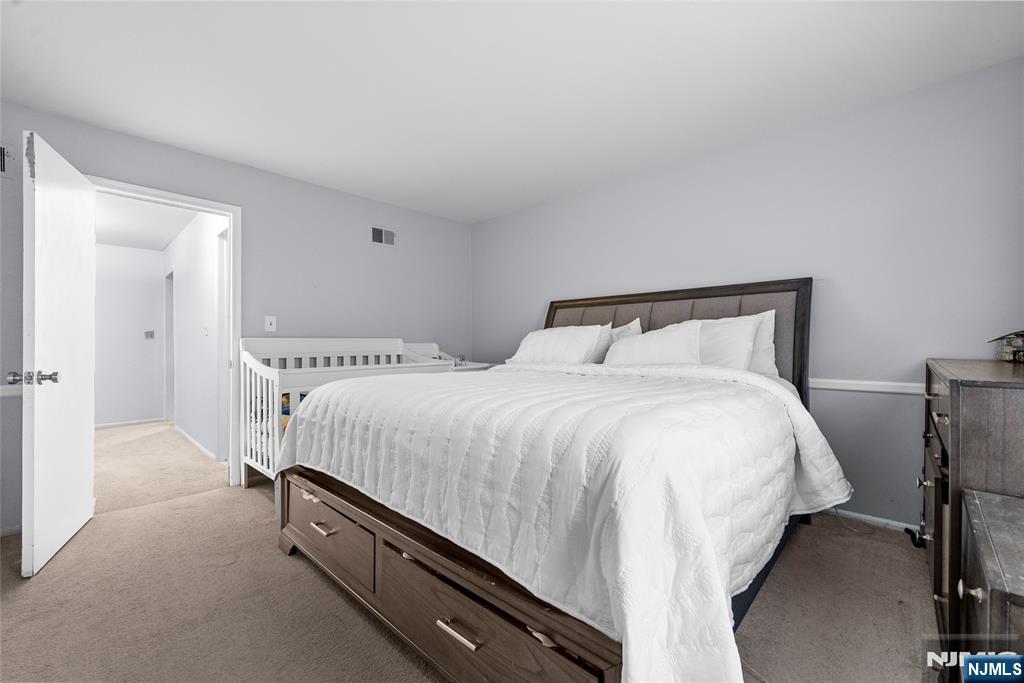 181 Long Hill Road, Unit 116 Little Falls, NJ 07424 - Photo 12 of 19 a bedroom with a bed and a night stand