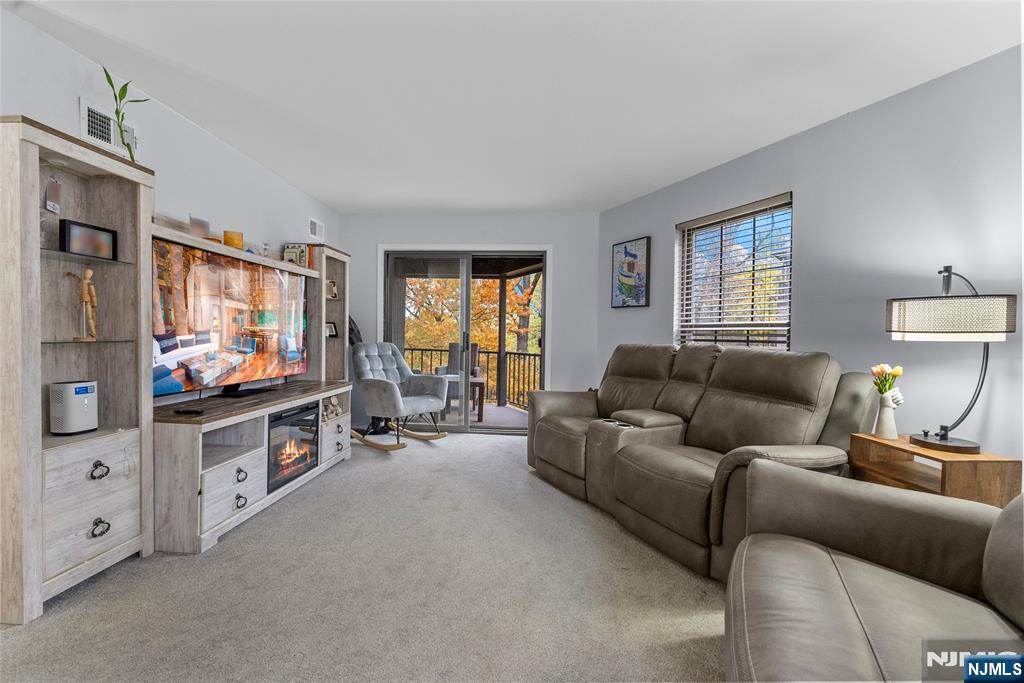 181 Long Hill Road, Unit 116 Little Falls, NJ 07424 - Photo 2 of 19 a living room with furniture and a flat screen tv