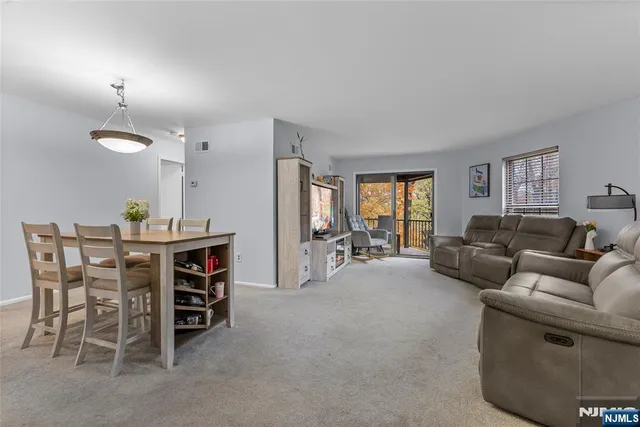 a living room with furniture and a dining table with projector