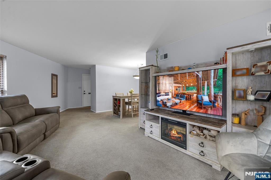 181 Long Hill Road, Unit 116 Little Falls, NJ 07424 - Photo 4 of 19 a room with furniture and a flat screen tv