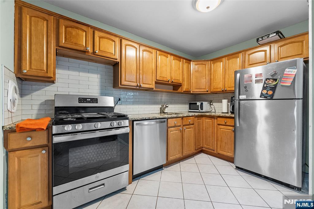 181 Long Hill Road, Unit 116 Little Falls, NJ 07424 - Photo 9 of 19 a kitchen with stainless steel appliances granite countertop a refrigerator stove top oven and sink