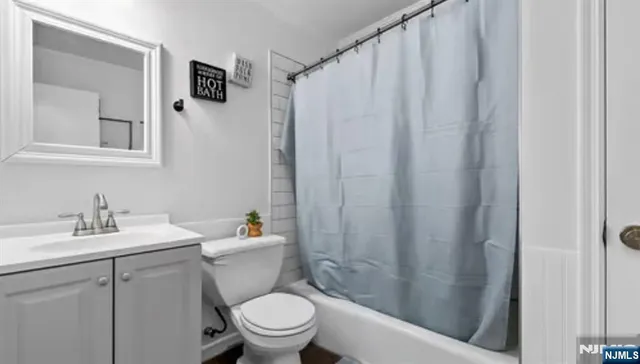 a bathroom with a sink a toilet and shower curtain