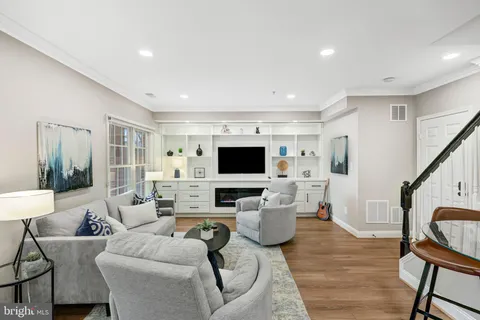 a view of a dining room and livingroom with furniture wooden floor a chandelier