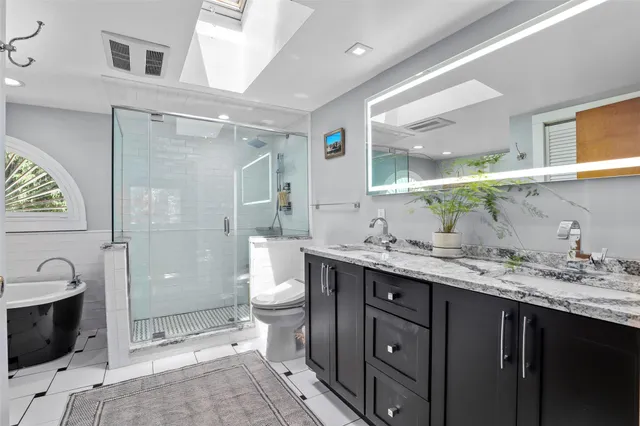 a bathroom with a granite countertop sink toilet and shower