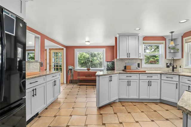 a large white kitchen with a window and cabinets