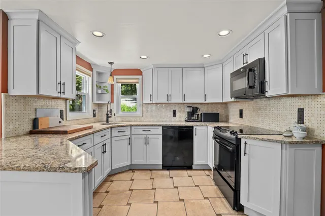 a kitchen with a stove sink and cabinets