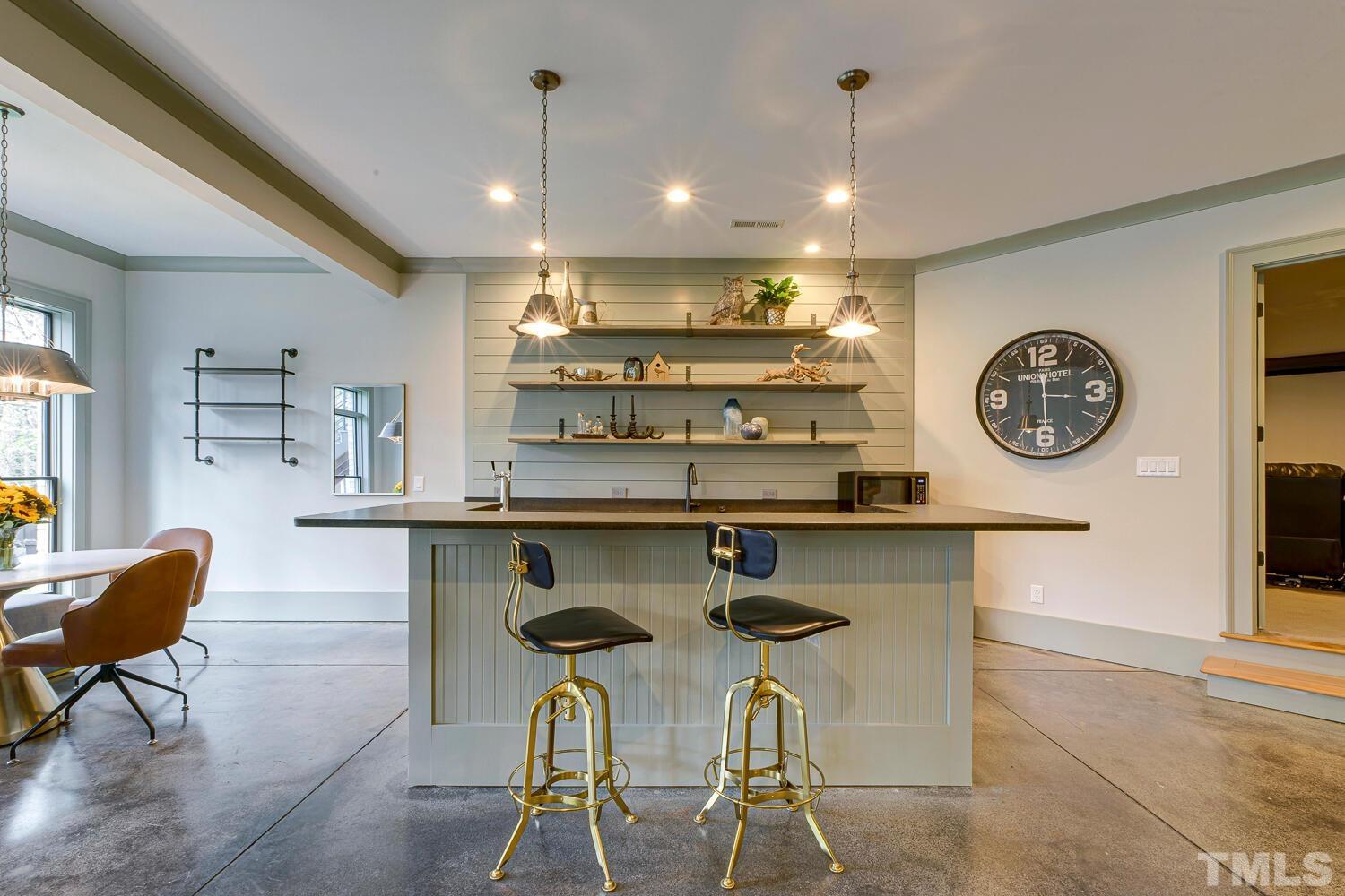 3521 Blue Ridge Road Raleigh, NC 27612 - Photo 71 of 100 a kitchen with a dining table chairs and a clock on the wall