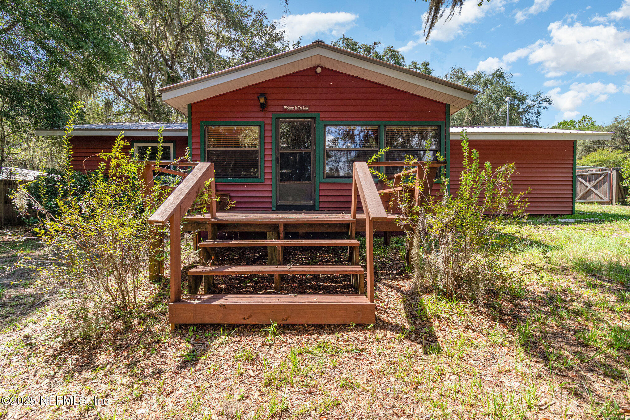 a view of a chairs and table in the patio next to a yard