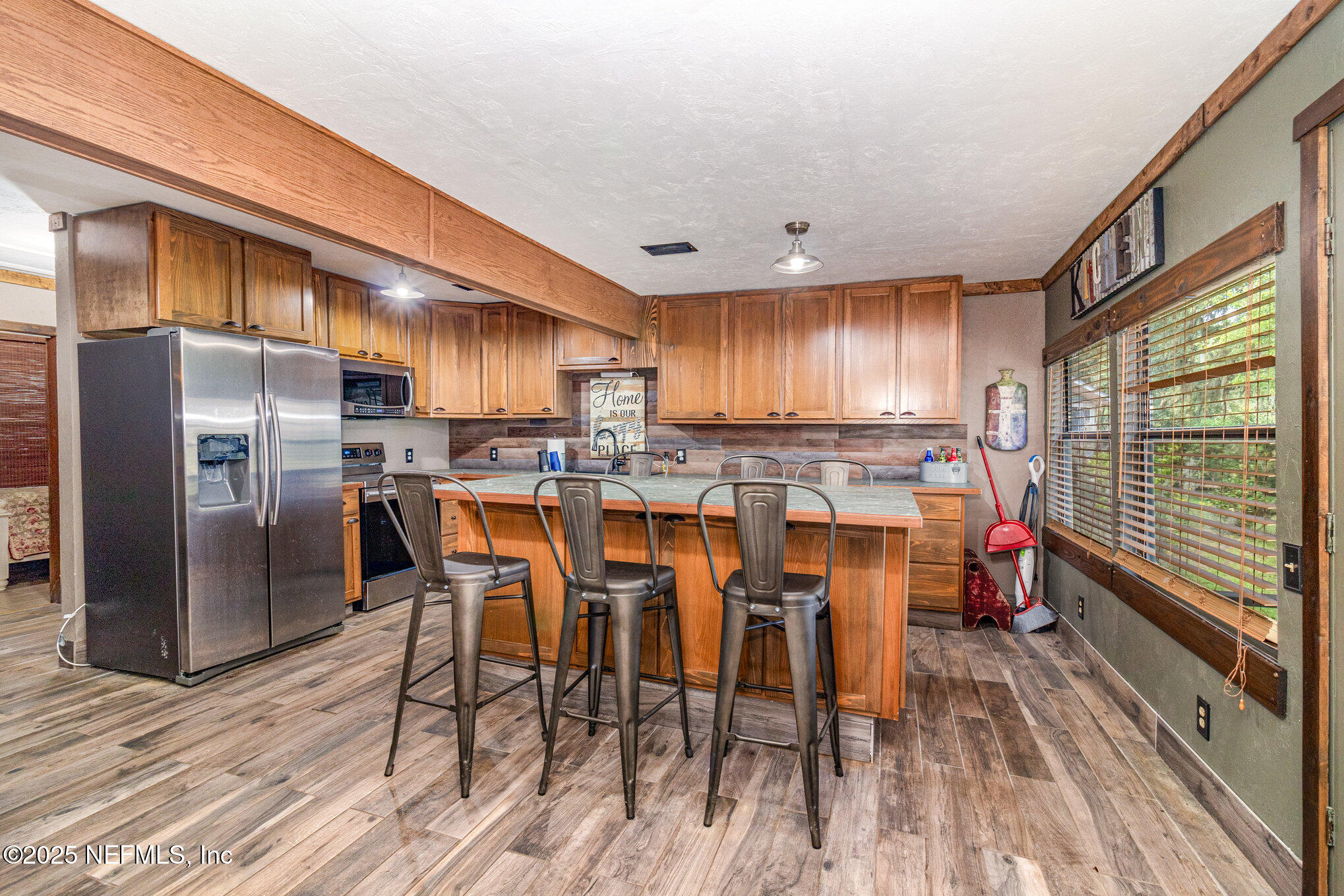 116 Lake Edge Trail Melrose, FL 32666 - Photo 3 of 9 a kitchen with stainless steel appliances granite countertop a refrigerator a sink dishwasher a stove and a dining table with wooden floor
