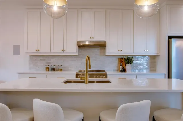 a kitchen with a white cabinets and chairs