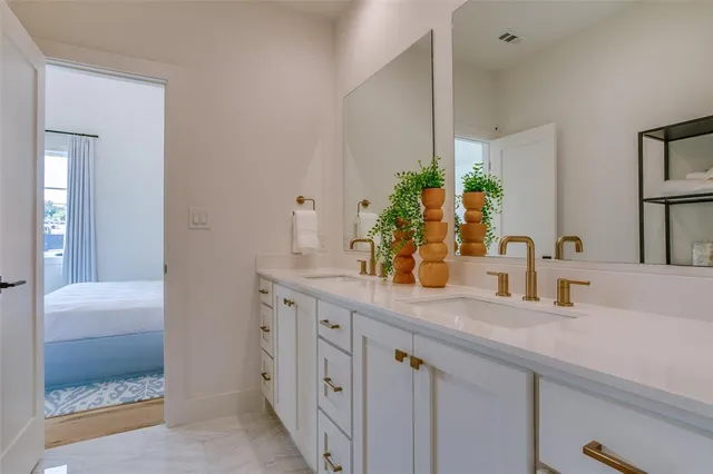 a bathroom with a granite countertop sink a mirror and a potted plant
