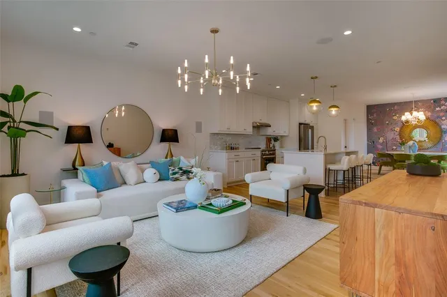 a living room with furniture a chandelier and a fireplace