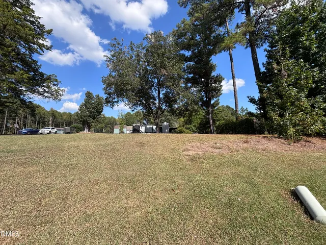 a view of a yard with a house and large trees