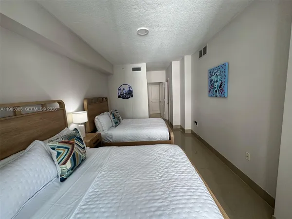 a bedroom with a bed and a lamp with the wooden floor