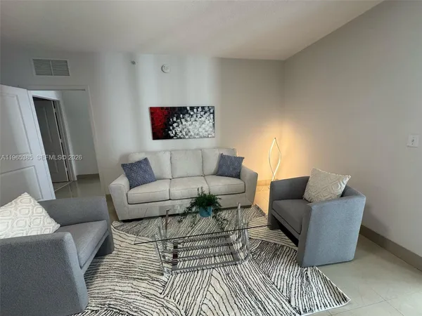 a living room with furniture a rug and a wall painting