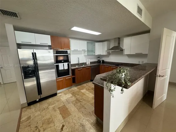 a kitchen with stainless steel appliances granite countertop a refrigerator and a stove