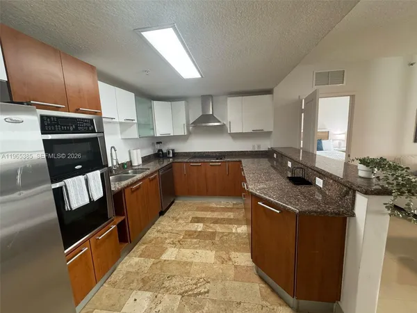 a kitchen with stainless steel appliances granite countertop a sink stove and cabinets
