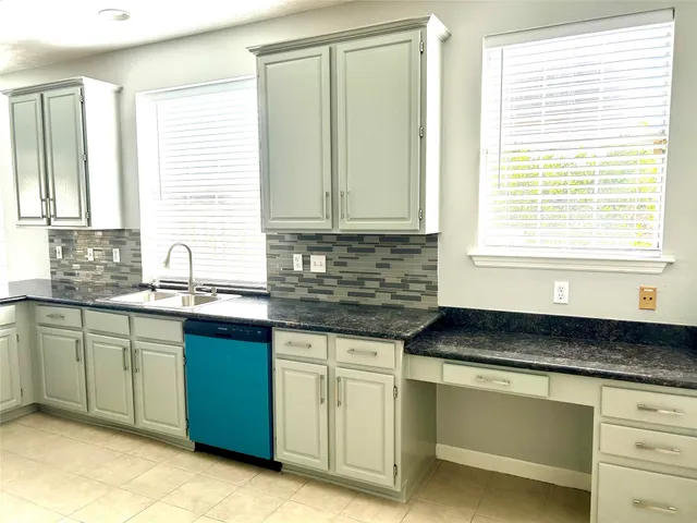a kitchen with granite countertop sink cabinets and window