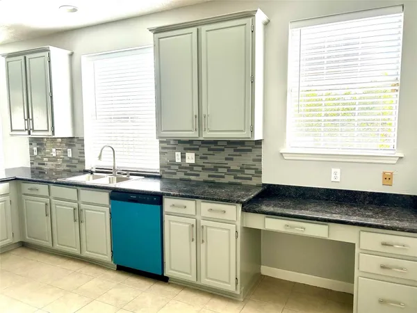 a kitchen with granite countertop a sink and white cabinets