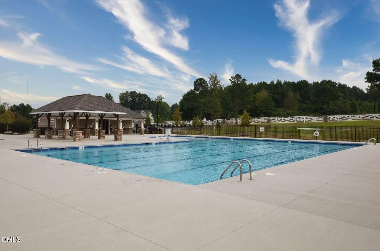 8 Tiger Eye Drive Clayton, NC 27520 - Photo 35 of 37 a view of swimming pool with outdoor seating and lake in the background