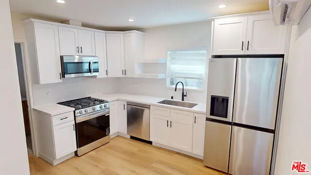 a kitchen with white cabinets and stainless steel appliances