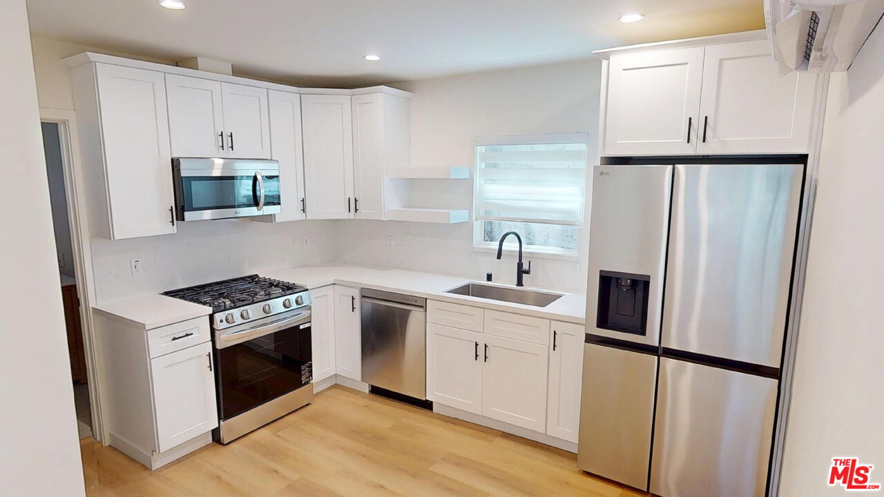a kitchen with white cabinets and stainless steel appliances
