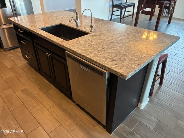 a kitchen with granite countertop sink and cabinets