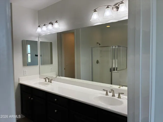 a bathroom with a double vanity sink mirror and shower