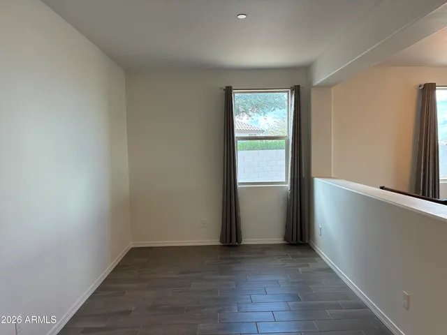 an empty room with wooden floor and window